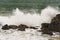 Angry waves crash over rocks on the coast during a summer storm