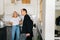 Angry wife scolding, raising voice, gesturing with hands, yelling at ignoring tired husband standing in kitchen room