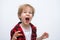 An angry wild child screams at the camera, ready to fight. Tantrums and disobedience crisis of three years and self-isolation,
