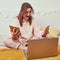 An angry woman screams with gadgets in her hands on a home bed. Problems with remote work during quarantine