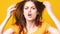 Angry woman screams and swears at the camera, hysterical woman on yellow background