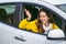 Angry woman waiting driver in the car and demonstrates gesture through open window.