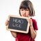 Angry young child holding a school slate as healthcare shield