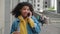 Angry young woman talking on smartphone outdoor. Irate african american girl with curly hair having unpleasant