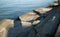 Angular broken concrete slabs at the edge of a calm ocean bay in late afternoon.