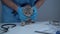 Animal doctor tries to examine naughty gray kitten on table in clinic. Male veterinarian and cheerful fidget feline at