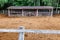 An animal farm with a shed and a pasture with dry hay fenced.