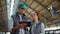 Animal farmers holding tablet computer in shed. Dairy farm supervisors talking.