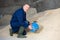 Animal feed warehouse worker pouring corn flour into bucket