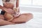 Animal sitting on the legs. Attractive blonde resting on the white bed with her cute kitten