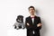 Animals, party and celebration concept. Sad dog owner crying, wearing suit, standing near cute black pug in costume