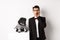 Animals, party and celebration concept. Shocked handsome man in formal suit and cute dog in costume, staring at camera