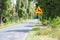 Animals - road sign standing on the roadside. Empty street ahead.