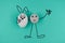 Animated pebble with a happy face, greeting and holds animated happy egg on blue paper background. Heppy easter