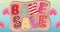 Animation of bake sale colourful pattern text over banner and flowers in background