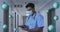 Animation of blue coronavirus cells moving over male doctor in face mask using tablet in hospital