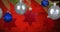 Animation of blue and silver baubles and red star christmas decoration hanging from christmas tree