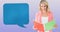 Animation of blue speech bubble over smiling caucasian woman reading notebook, on lilac