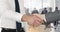 Animation of businessmen shaking hands over businesspeople and cityscape