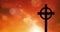 Animation of celtic cross over spots of light on orange sky with clouds