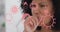 Animation of coronavirus icons over mixed race woman coughing at home