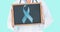 Animation of doctor holding blackboard with blue ribbon over blue background