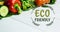 Animation of eco friendly text in green over fresh organic vegetables on wooden boards