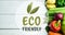 Animation of eco friendly text in green, over fresh vegetables on white wooden boards