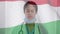 Animation of flag of hungary with gloved female doctor putting on face mask