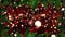 Animation of flickering white and red balls of light on black background with christmas tree border