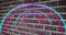 Animation of glowing neon blue and pink tunnel on brick wall
