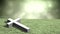 Animation of grey Christian cross lying on field of grass with glowing green clouds