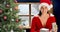 Animation of happy caucasian woman opening present over window and christmas tree