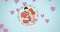 Animation of happy mother and father holding baby, in floral frame with pink hearts moving, on blue