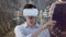 Animation of man smiling wearing vr headset using virtual interface, over modern city buildings