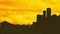 Animation of orange and yellow clouds moving over silhouette of cityscape at sunset