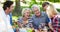 Animation of picnic basket over happy caucasian family having picnic in park