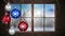 Animation of red, blue and silver baubles hanging with winter scenery