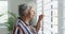 Animation of serious african american senior woman looking outside window