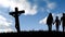 Animation of silhouette of Christian cross and couple with daughter with cloudy sky on background