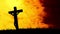 Animation of silhouette of Christian cross over yellow and orange clouds in background