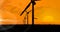 Animation of silhouetted wind turbines and plane taking off on orange sky with sunset