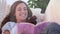 Animation of smiling woman relaxing and reading a book, over trees in sunshine