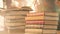 Animation of stack of books with autumn leaves falling over glowing lights