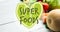 Animation of superfoods text in green on green heart, over fresh vegetables on white boards
