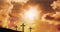 Animation of three christian crosses with glowing sun rays over orange sky