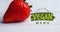 Animation of vegan menu text in green over fresh organic strawberry