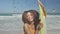 Animation of water droplets over smiling african american woman at beach with surfboard over sea