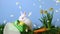 Animation of yellow flower petals floating over cute Easter bunny on blue background