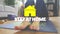 Animation of yellow house with social distancing message over Asian woman stretching